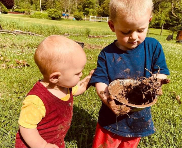 Small children playing with mud.